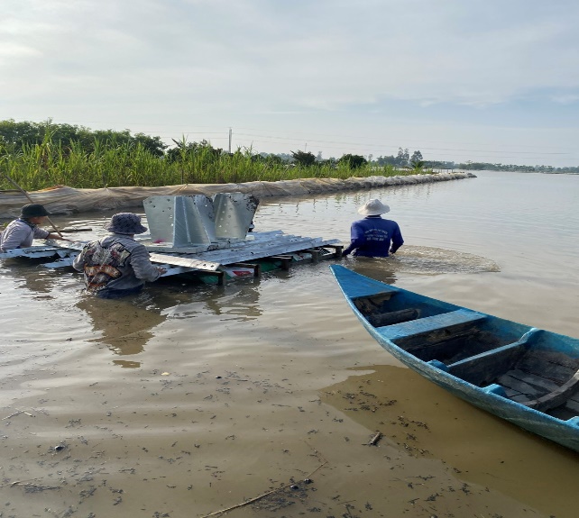 A group of people in a muddy river  Description automatically generated