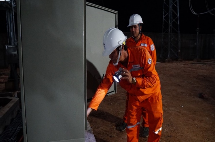 A group of men wearing orange jumpsuits and white helmets  Description automatically generated