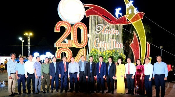 A group of people standing in front of a sign  Description automatically generated