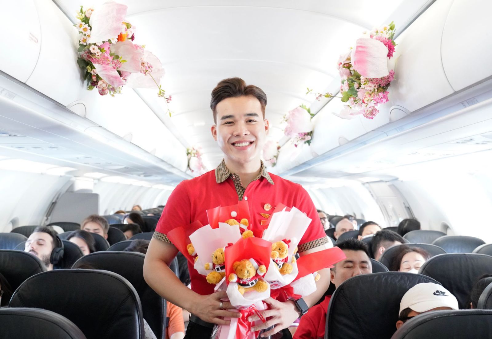 A person holding a bouquet of flowers in an airplane  Description automatically generated