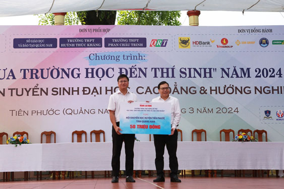 Ông Dương Quang, Phó Tổng Biên tập Báo Người Lao Động (phải), trao 50 triệu đồng cho Quỹ Khuyến học huyện Tiên Phước