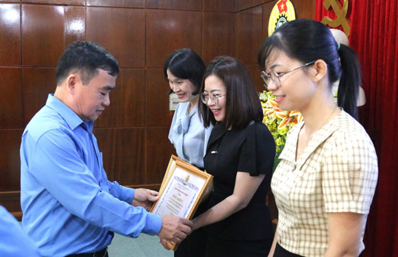 Ông Phan Xuân Quang, Chủ tịch LĐLĐ tỉnh Quảng Nam, trao bằng khen cho các tập thể, cá nhân có thành tích xuất sắc