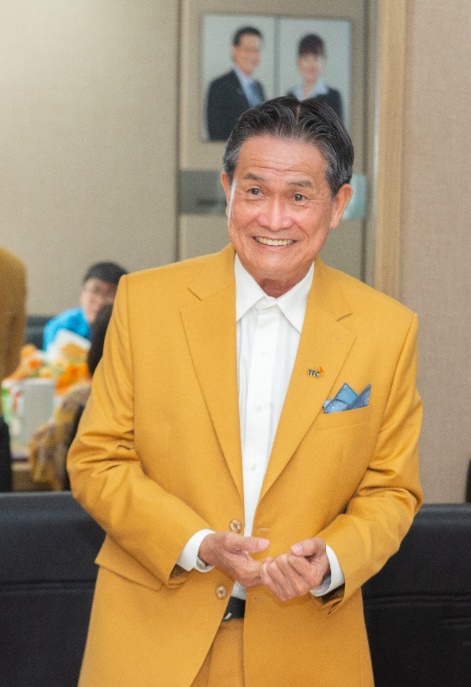 A person in a yellow suit  Description automatically generated