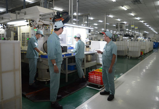 Anh Phạm Văn Phương (bìa phải) trao đổi công việc với công nhân tổ sản xuất. (Ảnh do nhân vật cung cấp)