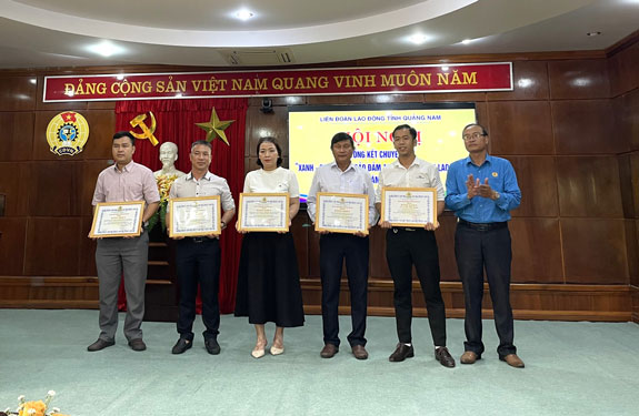 Ông Lưu Văn Thương, Phó Chủ tịch LĐLĐ tỉnh Quảng Nam (bìa phải), tặng bằng khen cho các tập thể, cá nhân có thành tích xuất sắc trong phong trào