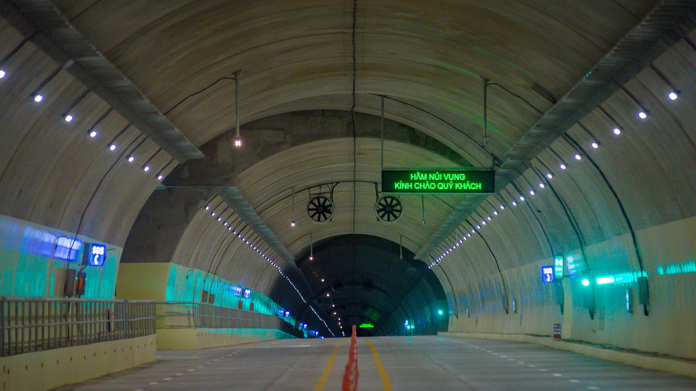 A tunnel with lights and signs  Description automatically generated