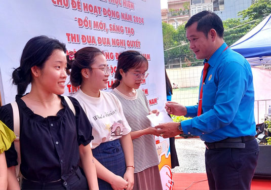 Ông Đinh Trần Thanh Tâm - Chủ tịch LĐLĐ quận Tân Bình, TP HCM - tặng quà cho người lao động khó khăn Ảnh: CAO HƯỜNG