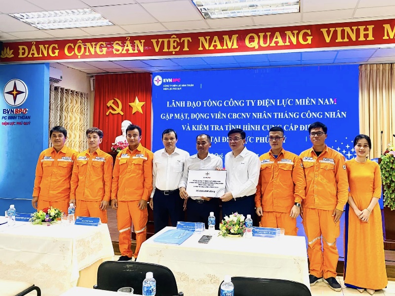 A group of people in orange jumpsuits standing in front of a banner  Description automatically generated