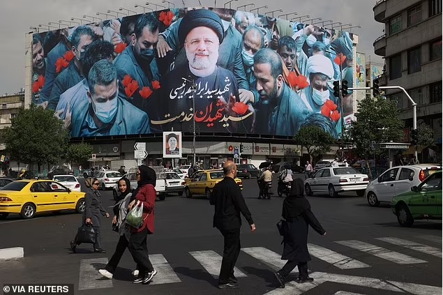 Người dân đi ngang qua bảng có hình cố Tổng thống Iran Ebrahim Raisi trên đường phố ở Tehran, Iran, ngày 21-5. Ảnh: Reuters