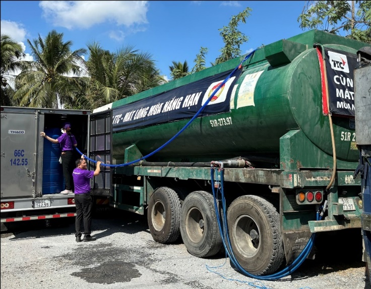 A person and person loading a tank truck  Description automatically generated with medium confidence