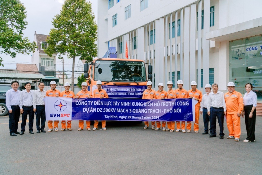 A group of people in orange jumpsuits holding a banner  Description automatically generated