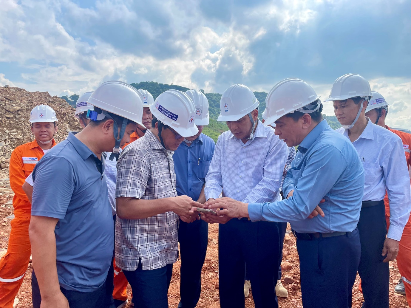 A group of men wearing white hard hats  Description automatically generated