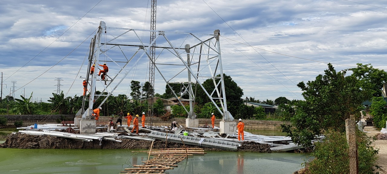 A group of people in orange uniforms working on a bridge  Description automatically generated