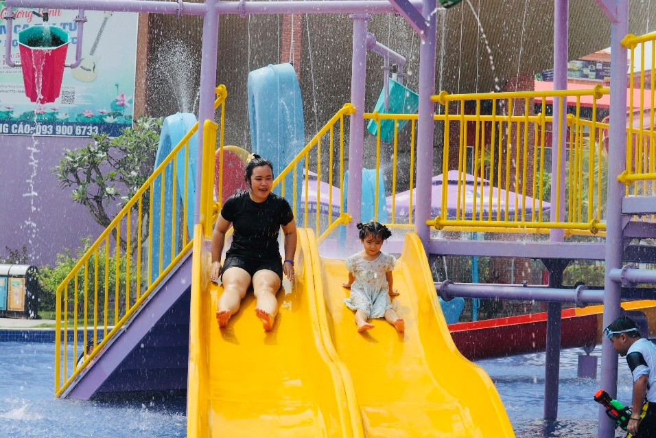 A person and child on a water slide  Description automatically generated