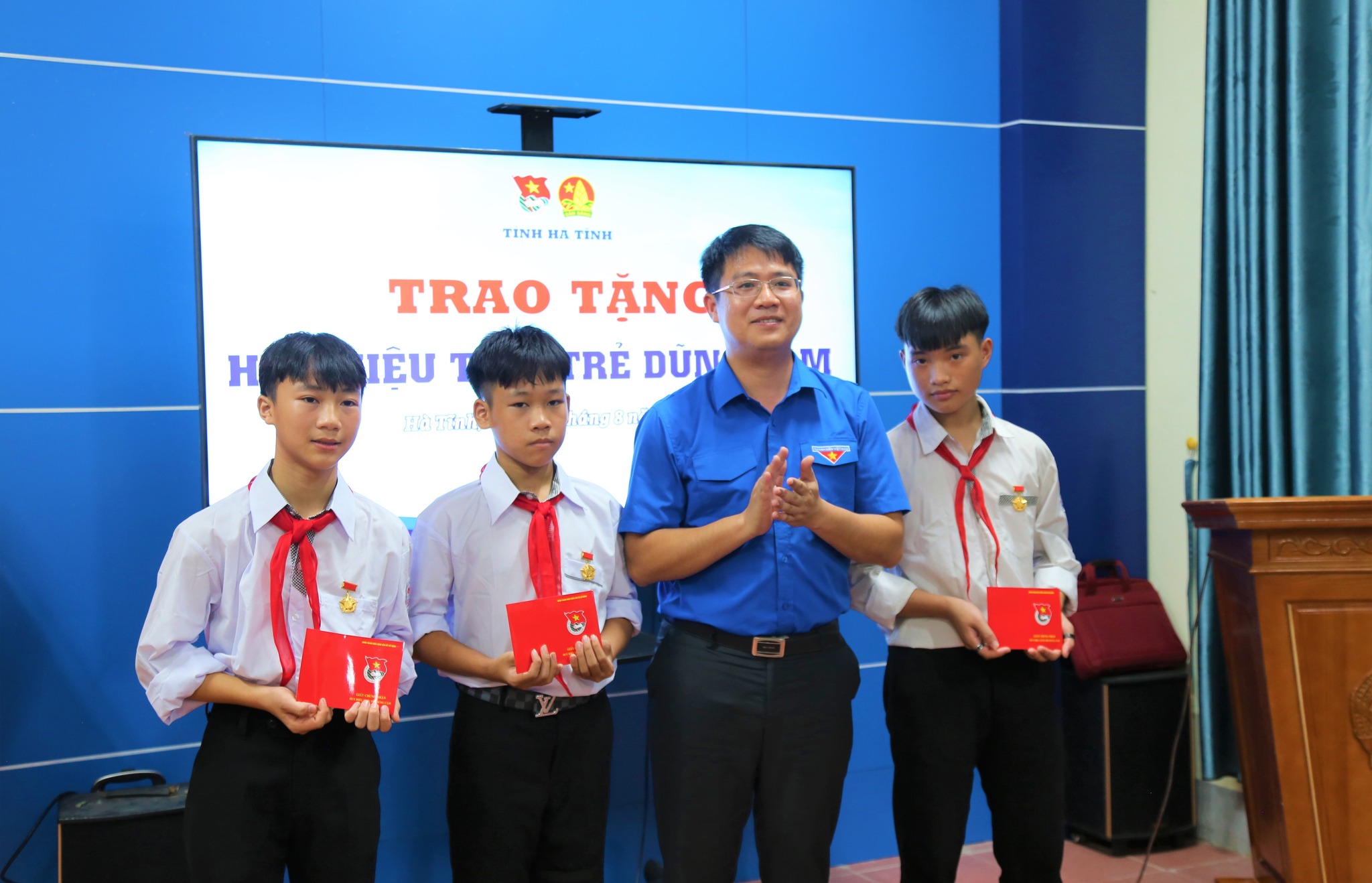 Đại diện Tỉnh đoàn, Huyện đoàn Thạch Hà trao Huy hiệu “Tuổi trẻ dũng cảm” cho 3 nam sinh. (Ảnh Thông tin Thạch Hà).