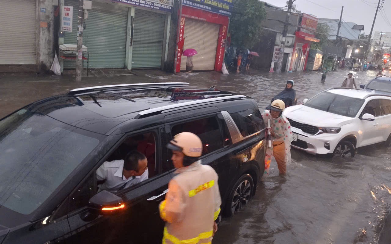 Mưa lớn ở TP HCM, cảnh sát giao thông lội nước cùng tài xế đẩy ô tô chết máy