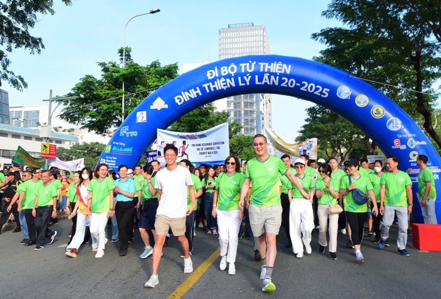 A group of people walking under a blue arch  Description automatically generated