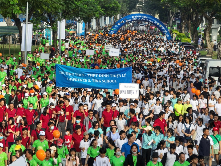 A large group of people walking in a street  Description automatically generated