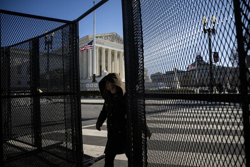 A person walks through a gap in temporary security fencing at the US Supreme Court in Washington DC.