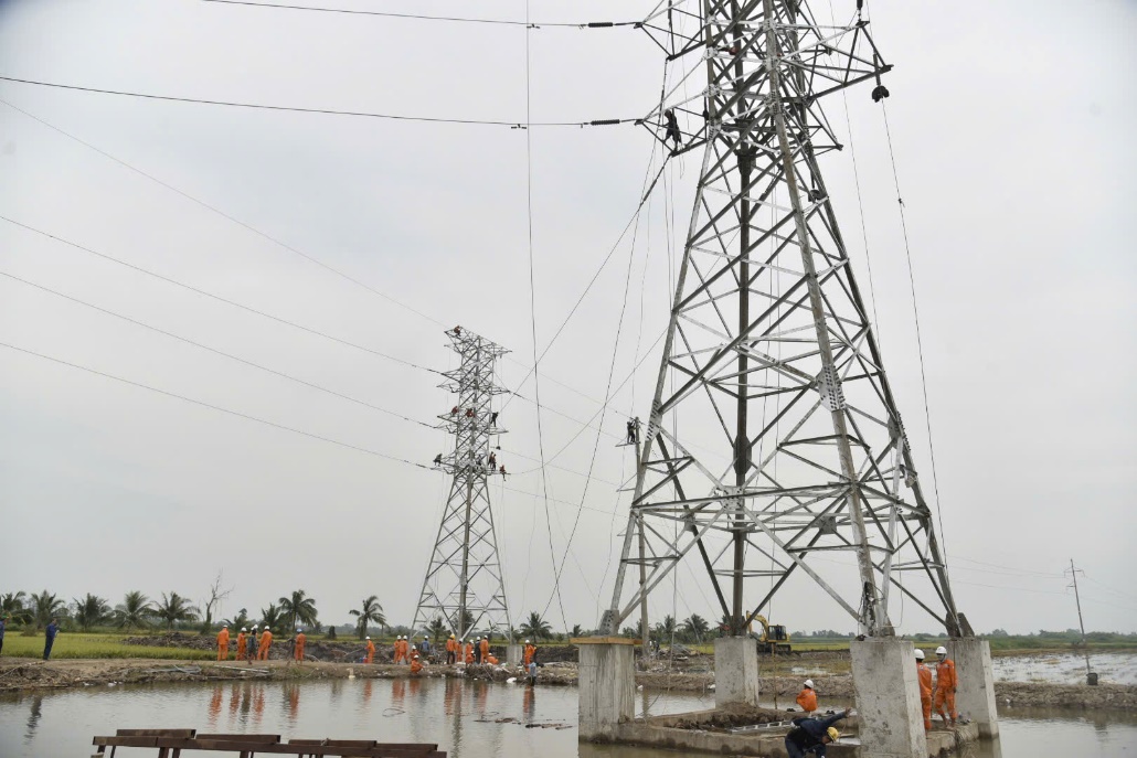 A group of people working on a power line  Description automatically generated