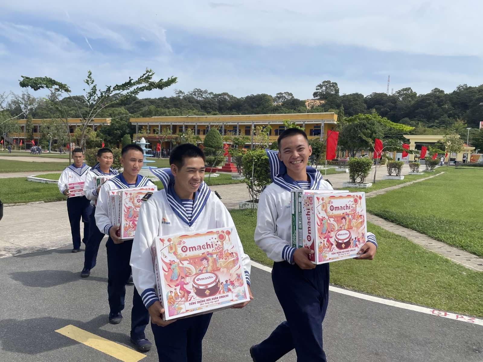 A group of young men carrying boxes  Description automatically generated