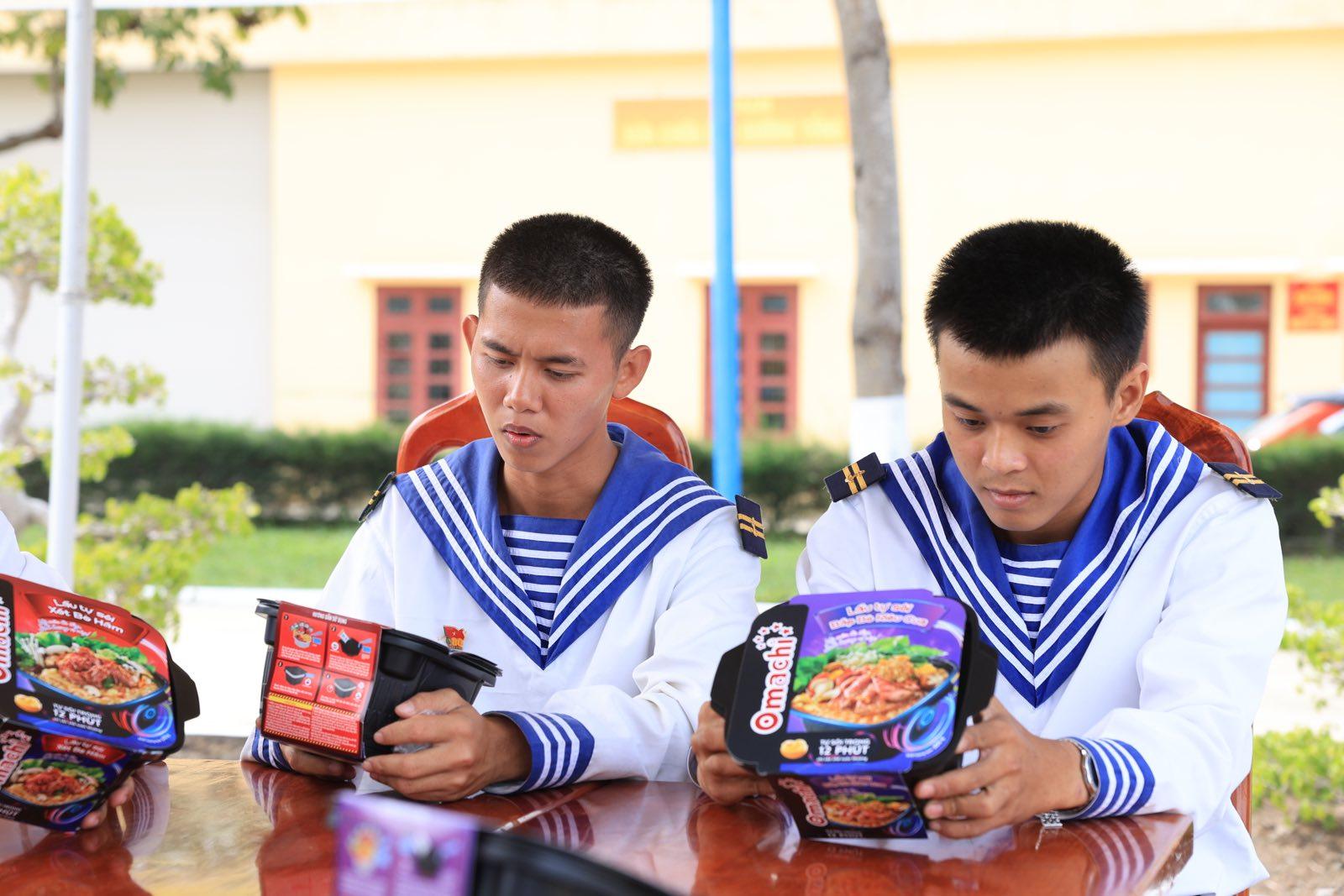 A couple of young men wearing sailor uniforms sitting at a table  Description automatically generated