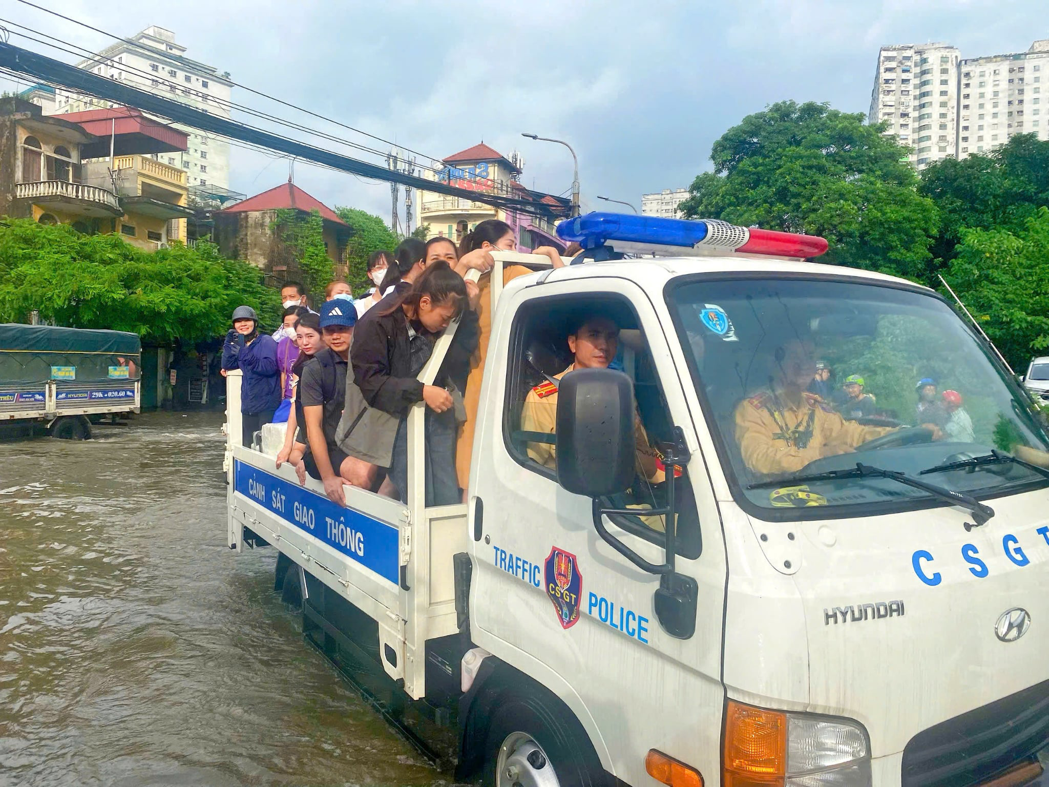 CSGT hỗ trợ người dân vượt điểm ngập nước tại Hà Nội trong Mưa lớn - Ảnh 1.