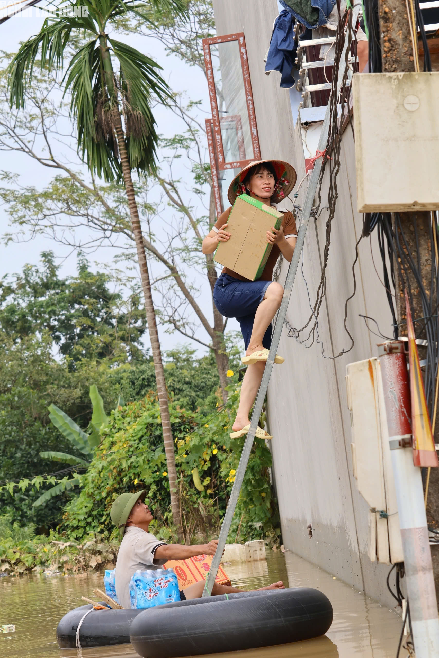 Lũ rút chậm, người dân Bắc Ninh chèo thuyền tự chế, trèo thang nhận đồ tiếp tế   - Ảnh 1.