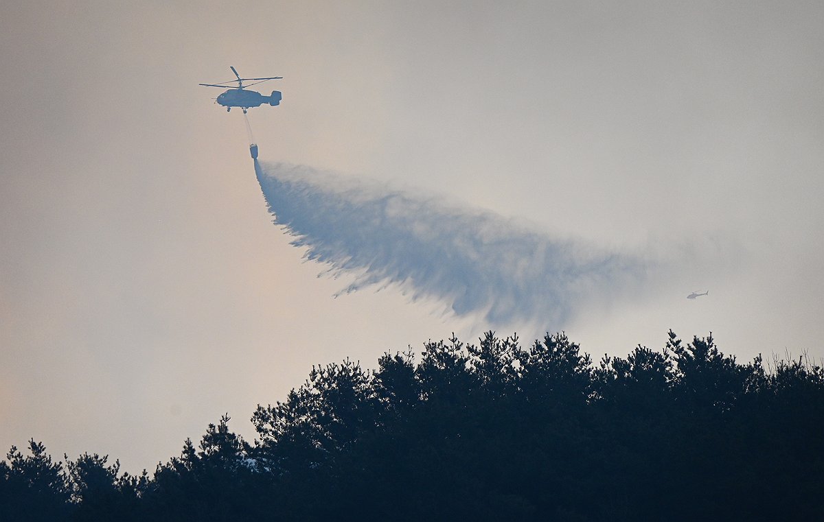 Authorities put out a fire using a helicopter on March 22, 2025, a day after a wildfire broke out in the southeastern county of Sancheong, in this photo provided by the South Gyeongsang provincial government. (PHOTO NOT FOR SALE) (Yonhap)