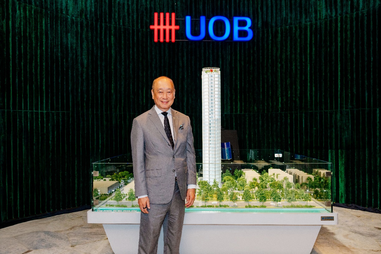 UOB tái khẳng định cam kết đầu tư mạnh mẽ vào thị trường Việt Nam - Ảnh 2. A person in a suit standing in front of a model of a tall building AI-generated content may be incorrect.