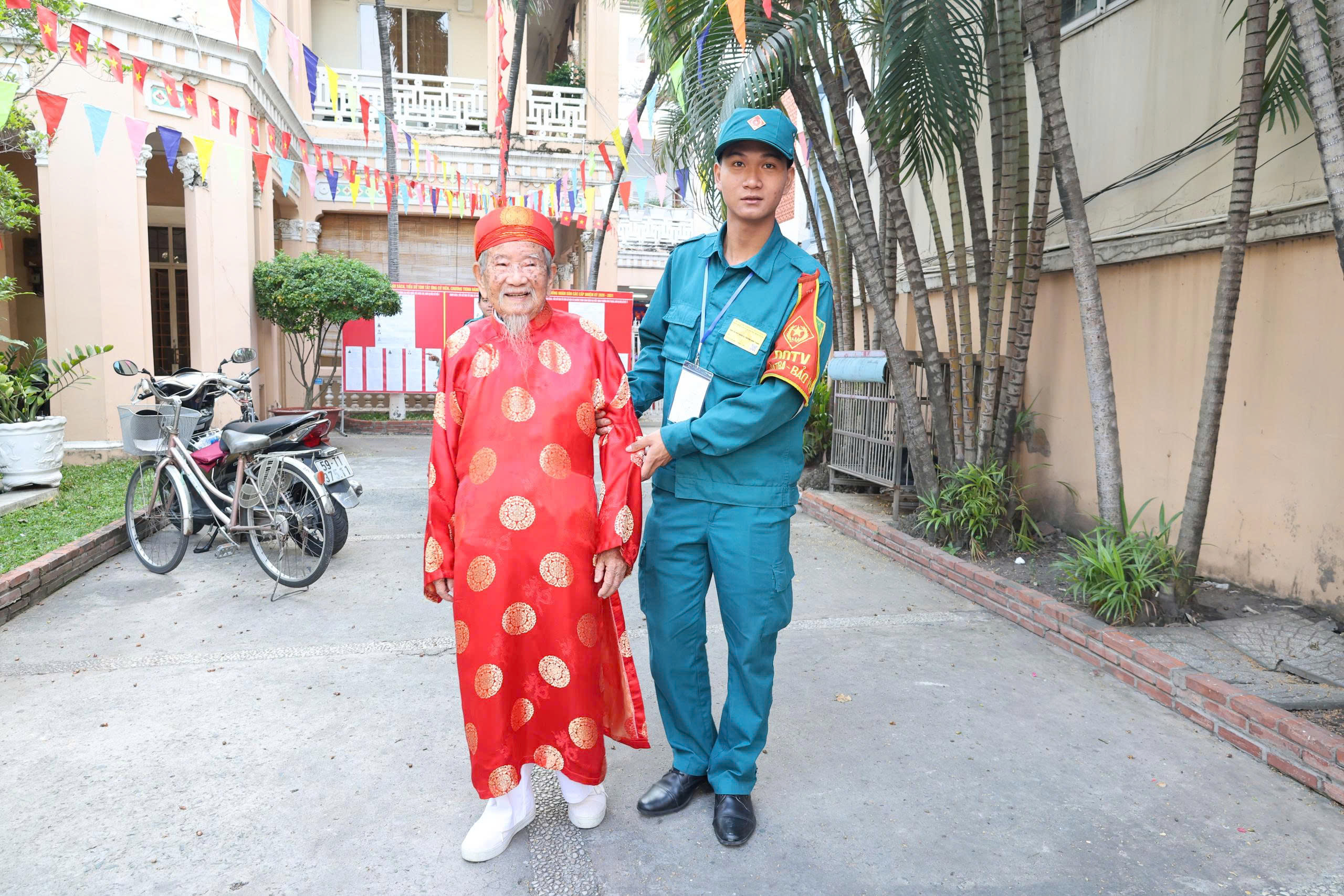 Nhà nghiêu cứu Nguyễn Đình Tư 106 tuổi trong áo dài đỏ đi bầu cử - Ảnh 2.