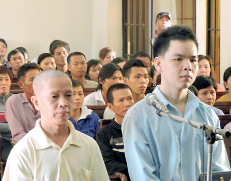 
Hai bị cáo Bùi Thanh Hoài (bìa phải) và Lương Tấn Khanh tại tòa.
