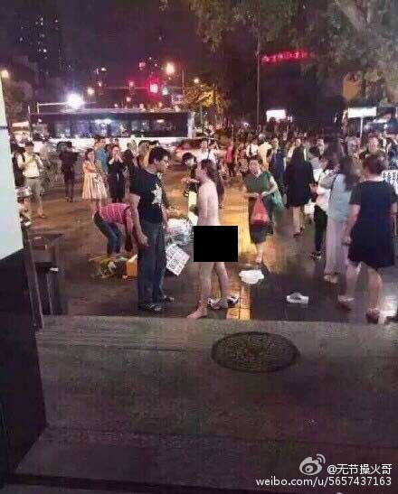 Cô gái cởi hết đồ trong lẫn đồ ngoài trước mặt hàng chục người hiếu kỳ. Ảnh: Weibo