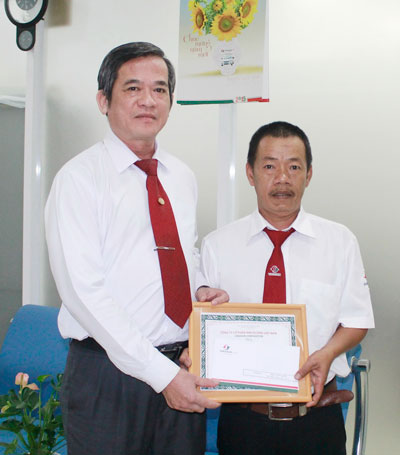 Ông Huỳnh Văn Sỹ (bìa trái), Phó Tổng Giám đốc Vinasun, trao giấy khen và tiền thưởng cho tài xế La Đức Hiên