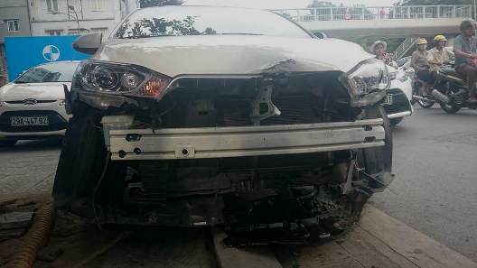 Chiếc xe trắng bị nát đầu sau vụ tai nạn