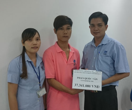 Ông Lê Trần Thanh Hải, Chủ tịch Công đoàn Công ty TNHH May mặc Triple Việt Nam (bìa phải), trao tiền hỗ trợ cho vợ chồng anh Tân và chị Lương