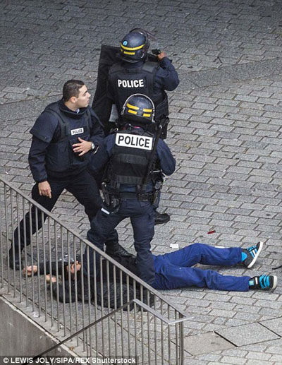 Một nghi can bị bắt giữ trong cuộc vây ráp tại St. Denis Ảnh: REX