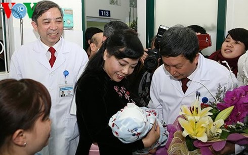 
Bộ trưởng Y tế thăm cháu bé đầu tiên ra đời bằng phương pháp mang thai hộ tại Việt Nam. (Ảnh: Văn Hải)
