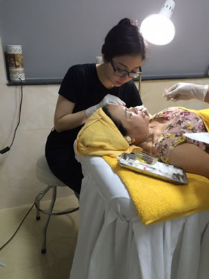 Ca sĩ Thùy Linh trong vai trò nhân viên thẩm mỹ đang chăm sóc sắc đẹp cho khách hàng