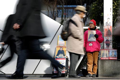 Một cụ già vô gia cư bán báo trên đường phố ở Tokyo Ảnh: BLOOMBERG