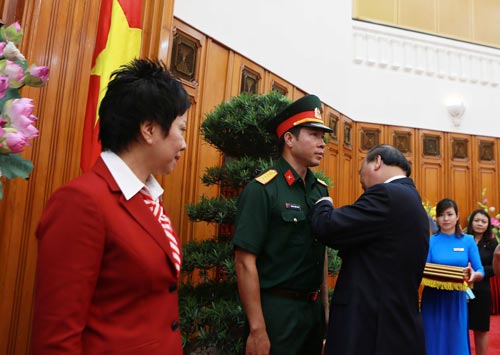 Thủ tướng Nguyễn Xuân Phúc gắn Huân chương Lao động hạng nhất cho xạ thủ Hoàng Xuân Vinh Ảnh: HẢI ANH
