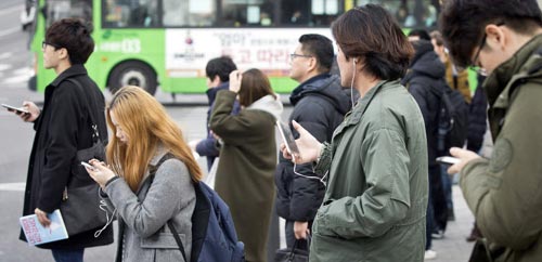 Nhiều người mải mê dùng smartphone ngoài đường phố ở thủ đô Seoul - Hàn Quốc Ảnh: CHOSUN ILBO