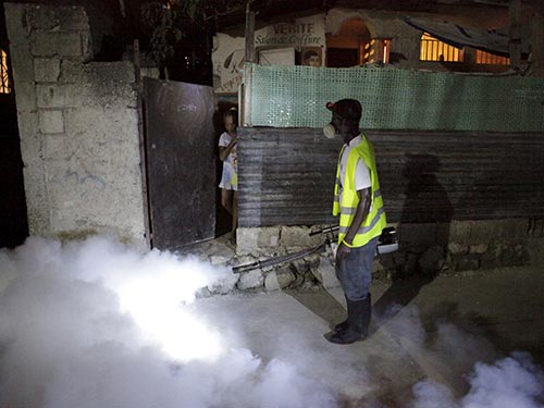 Nhân viên y tế phun thuốc diệt muỗi để ngăn chặn virus Zika tại thủ đô Port-au-Prince của Haiti hôm 2-2 Ảnh: REUTERS