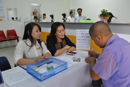 Nhân viên bưu điện hướng dẫn người dân đến đổi mới giấy phép lái xe tại Bưu điện Bình Chánh (TP HCM)