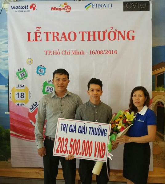 
Anh Trần Thanh V (giữa) nhận giải nhất xổ số điện toán (Ảnh: T. Dương)
