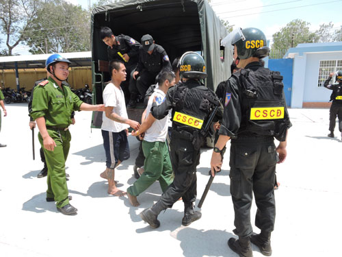 Lực lượng cảnh sát hỗ trợ đưa học viên trốn trại quay lại trung tâm cai nghiện Ảnh: NGỌC GIANG