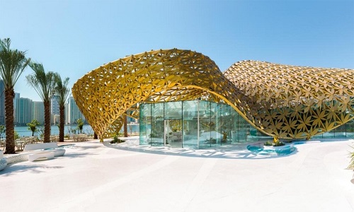 
Công ty 3deluxe, Đức, xây dựng ngôi nhà Butterfly Pavilion dành cho hơn 500 loài bướm trên đảo Noor thuộc Các Tiểu vương quốc Arab thống nhất (UAE). Bên ngoài tòa nhà là bộ khung gồm hơn 4.000 chiếc lá nhôm màu vàng liên kết với nhau, bao phủ khối kiến trúc thủy tinh hình lập phương bên trong. Thiết kế này giúp điều hòa khí hậu bên trong ngôi nhà cũng như mang đến cảm giác giống như những cánh bướm đang bay khi nhìn từ xa.
