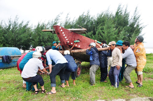 Hai tàu cá của ngư dân tỉnh Quảng Ngãi bị chìm ở cửa biển Cửa Đại (ảnh trên) và di dời các thuyền vào bờ tránh bão tại tỉnh Quảng NamẢnh: TỬ TRỰC-TRẦN THƯỜNG