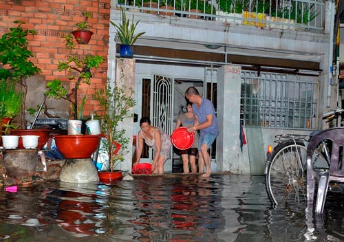 Người dân sống trên đường Nguyễn Văn Quá thức trắng đêm tát nước sau một cơn mưa lớn Ảnh: Như Thảo