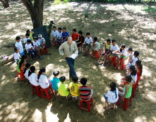 Ông Bruno dạy tiếng Anh cho trẻ em nghèo tại sân Trường Tiểu học số 1 Tịnh Khê thông qua các trò chơi